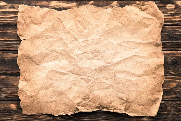 Top view of blank crumpled paper on rustic wooden surface — Stock Photo