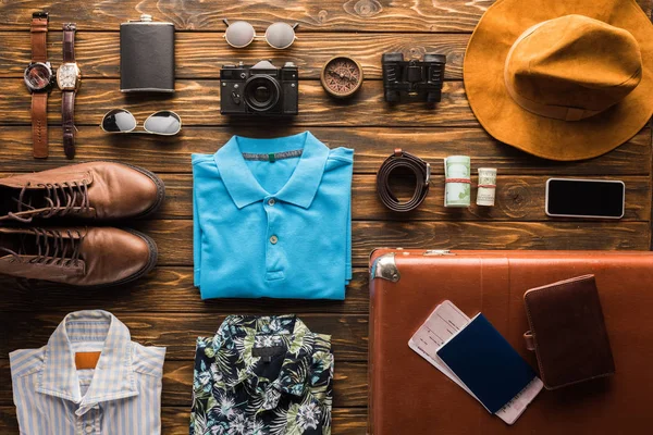 Top view of vintage suitcase with baggage for travel on wooden surface — Stock Photo