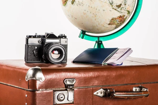 Фільм камера з авіаквитків і глобусом на марочні чемодан, ізольовані на білому — стокове фото