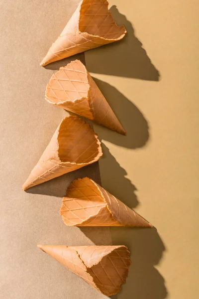 Vista superior de cones de sorvete vazios na superfície cinza e bege — Fotografia de Stock