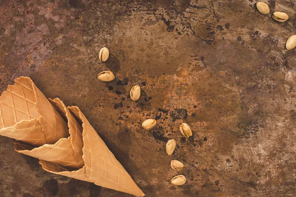 Vue du dessus des cônes de crème glacée vides et des pistaches sur la table — Photo de stock