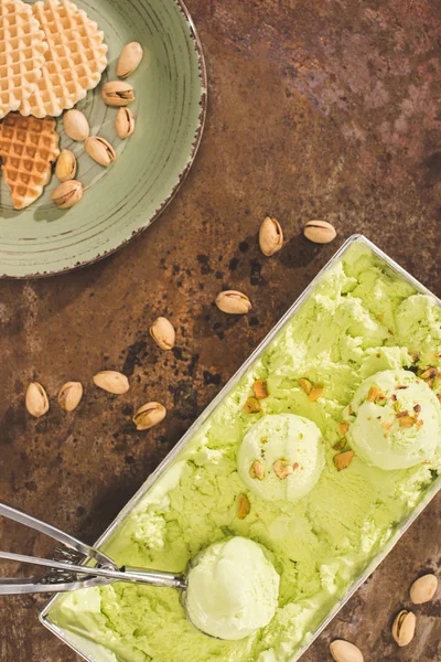 Vista superior de helado de pistacho verde con cucharada en la mesa - foto de stock