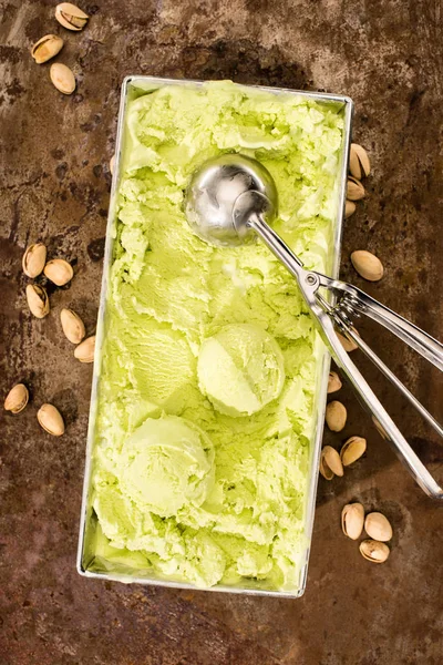 Top view of pistachio ice cream with ice cream scoops on table — Stock Photo