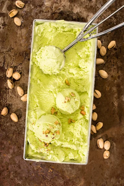 Elevated view of pistachio ice cream with scoop on table — Stock Photo
