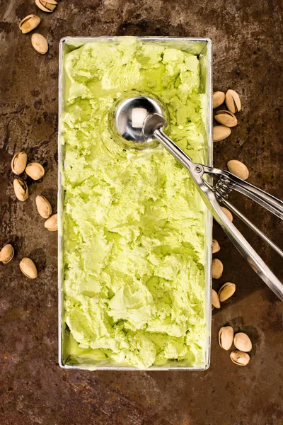 Vista superior de sorvete de pistache e colher na mesa — Fotografia de Stock