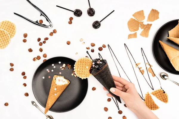 Cropped image of woman holding black ice cream isolated on white — Stock Photo