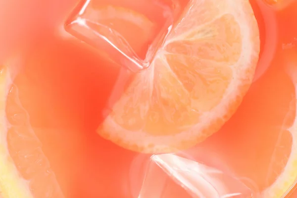 Close up view of fresh cocktail with ice cubes and lemon pieces background — Stock Photo