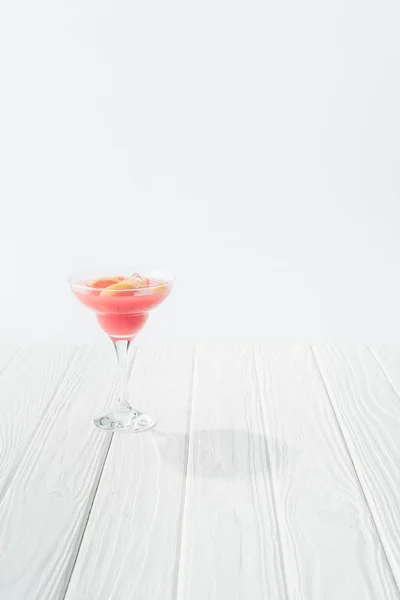 Close up view of tasty summer alcohol cocktail on white wooden tabletop on grey background — Stock Photo