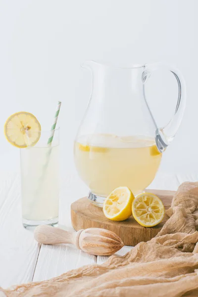 Nahaufnahme von Krug und Glas Limonade auf weißer Holzoberfläche vor grauem Hintergrund — Stockfoto