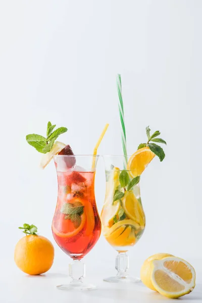 Close up view of summer fresh cocktails with strawberry, lemon and oranges, mint and straws isolated on white — Stock Photo