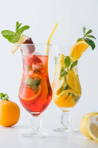 Close up view of summer fresh cocktails with strawberry, lemon and orange pieces, mint isolated on white — Stock Photo