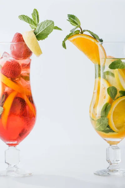 Nahaufnahme von sommerfrischen Cocktails mit Zitronen- und Orangenstücken, Minze isoliert auf Weiß — Stockfoto