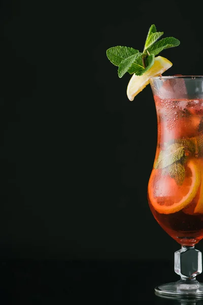 Nahaufnahme von sommerfrischem Cocktail mit Minz-, Zitronen- und Orangenstücken isoliert auf schwarz — Stockfoto