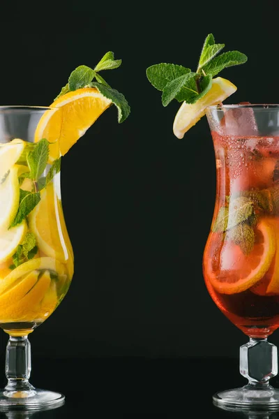 Nahaufnahme von sommerfrischen Cocktails mit Minz- und Zitrusstücken isoliert auf schwarz — Stockfoto