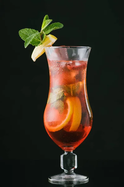 Vue rapprochée de cocktail frais d'été avec des morceaux de menthe, citron et orange isolés sur noir — Photo de stock