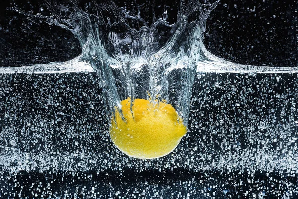 Close up view of lemon in water isolated on black — Stock Photo