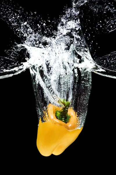 Закрытый вид движения желтого колокольчика, падающего в воду, изолированный на черный — стоковое фото