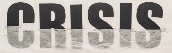 Plano panorámico de crisis palabra negra inmerso en papel que simboliza el agua aislada en blanco - foto de stock