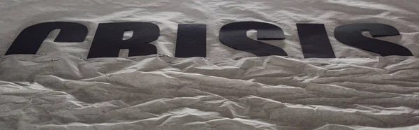 Colpo panoramico di crisi della parola nera immerso nella carta grigia che simboleggia l'acqua — Foto stock