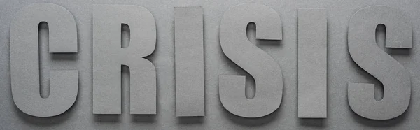 Vista superior de la palabra crisis sobre fondo gris con sombras, plano panorámico - foto de stock