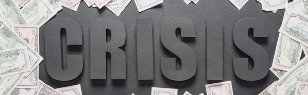 Vista superior de la palabra crisis en el marco de billetes de dólar sobre fondo negro con sombras, plano panorámico - foto de stock