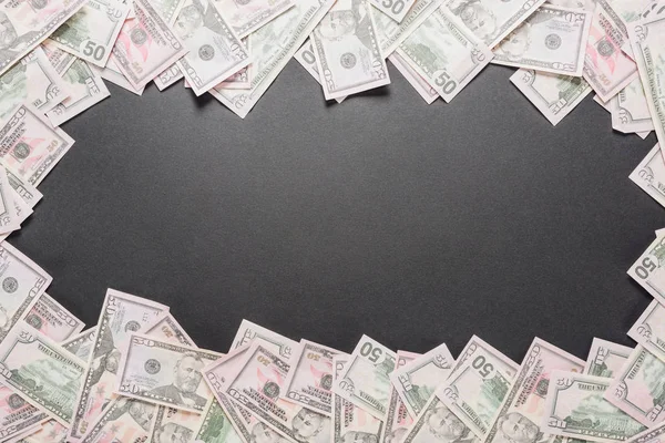 Frame of scattered dollar banknotes on black background with copy space — Stock Photo