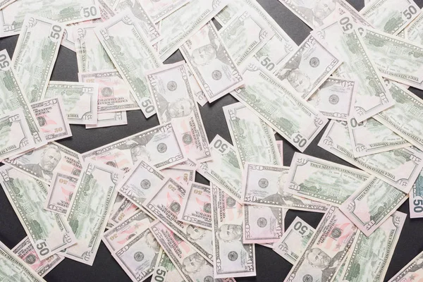 Vista superior das notas de dólar espalhadas sobre fundo cinzento — Fotografia de Stock