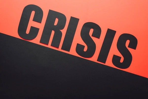 Верхний вид слова кризис на черном и красном фоне, разделенный наклонной линии — стоковое фото