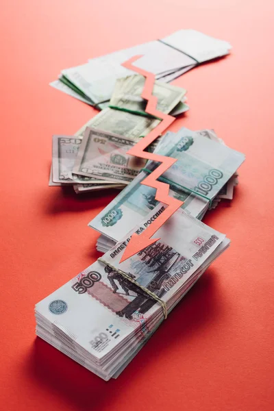 Selective focus of paper cut recession arrow on ruble, dollar and euro banknotes on red background — Stock Photo