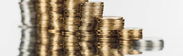 Selective focus of stacked silver and golden coins on surface with reflection isolated on white, panoramic shot — Stock Photo