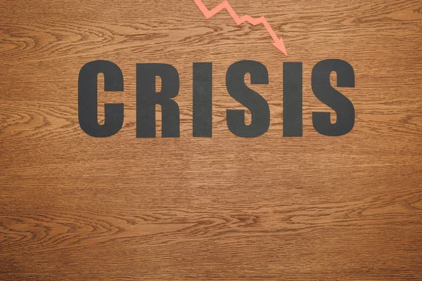 Draufsicht auf schwarzes Papier geschnitten Wort Krise und Rezession Pfeil auf Holzoberfläche mit Kopierraum — Stockfoto