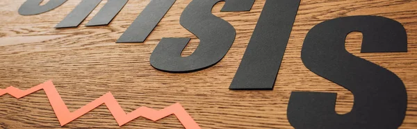 Plano panorámico de papel recortado palabra crisis cerca del diagrama en la superficie de madera - foto de stock