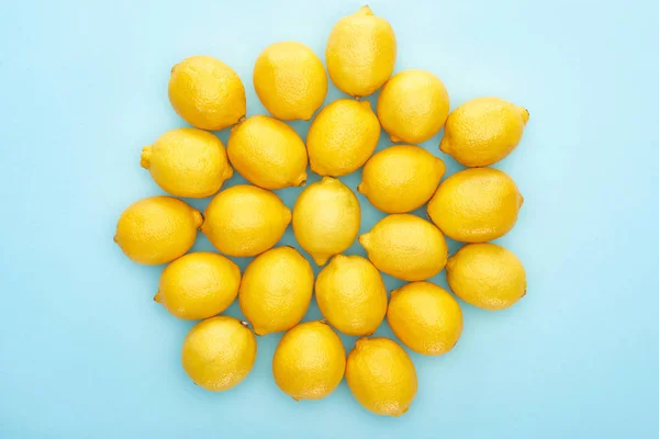 Vue du dessus des citrons jaunes mûrs sur fond bleu — Photo de stock
