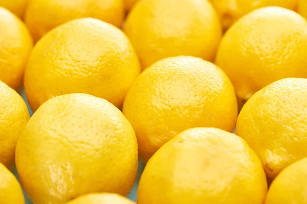 Vista de cerca de limones amarillos maduros sobre fondo azul - foto de stock