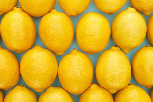 Вид зверху на стиглі жовті лимони на синьому фоні — стокове фото