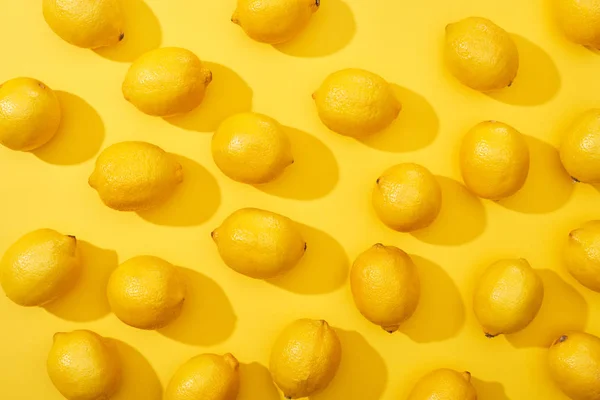 Vista superior de limones maduros sobre fondo amarillo - foto de stock