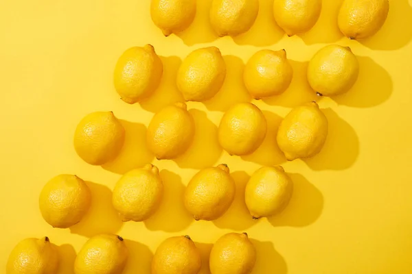 Vista superior de limones maduros sobre fondo amarillo - foto de stock