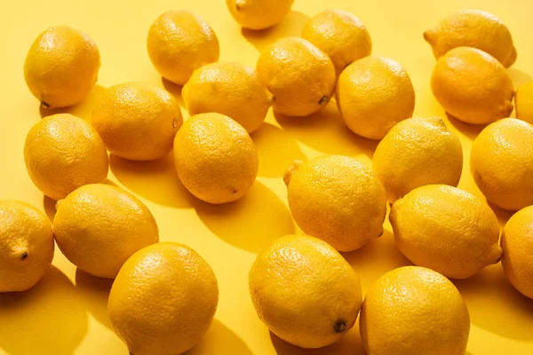 Limoni interi maturi su fondo giallo — Foto stock