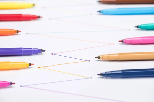 Selective focus of colorful felt-tip pens on white background with connected drawn lines, connection and communication concept — Stock Photo