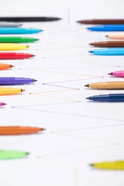 Selective focus of multicolored felt-tip pens on white background with connected drawn lines, connection and communication concept — Stock Photo