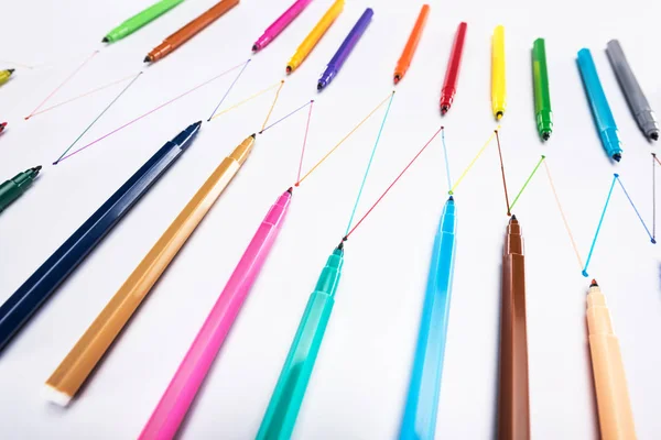 Selective focus of felt-tip pens on white background with connected drawn lines, connection and communication concept — Stock Photo