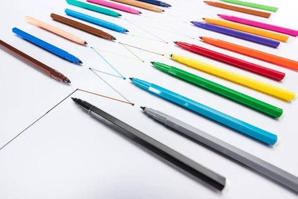 Stylos feutre multicolores sur fond blanc avec lignes tracées reliées, concept de connexion et de communication — Photo de stock