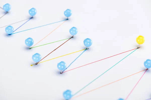 Vista de cerca de líneas dibujadas conectadas coloridas con alfileres, conexión y concepto de liderazgo - foto de stock