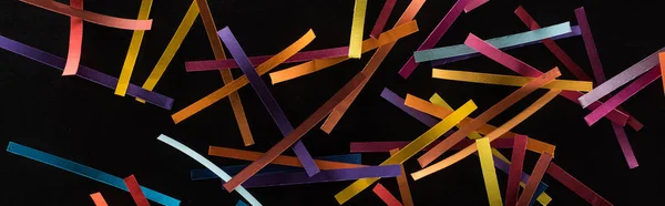 Вид зверху на різнокольорові абстрактні лінії, розкидані ізольовані на чорному тлі, концепція зв'язку та зв'язку — стокове фото