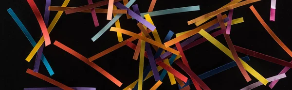 Vista superior de líneas abstractas multicolores dispersas sobre fondo negro, conexión y concepto de comunicación - foto de stock