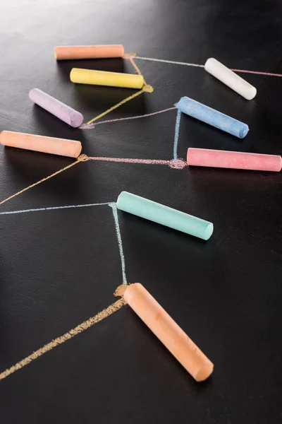 Colorful chalk on black surface with connected drawn lines, connection and communication concept — Stock Photo