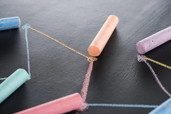 Colorful chalk on black surface with connected drawn lines, connection and communication concept — Stock Photo