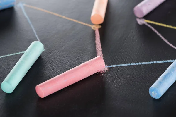 Selective focus of colorful chalk on black surface with connected drawn lines, connection and communication concept — Stock Photo