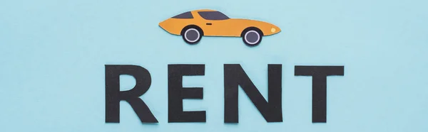 Draufsicht auf papiergeschnittenen Sportwagen und schwarzen Rent-Schriftzug auf blauem Hintergrund, Panoramaaufnahme — Stockfoto