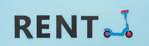 Draufsicht auf Papier geschnittenen Tretroller und schwarzen Mietschriftzug auf blauem Hintergrund, Panoramaaufnahme — Stockfoto